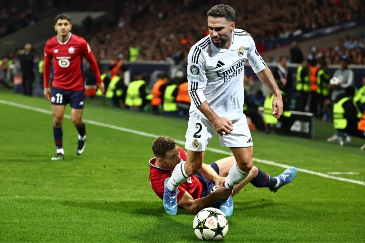 Real Madrid's Spanish defender #02 Dani Carvajal (front) and Lille's Sweden's defender #05 Gabriel Gudmundsson fight for the ball during the UEFA Champions League football match between Lille LOSC and Real Madrid at the Pierre Mauroy Stadium in Villeneuve-d'Ascq, northern France, on October 2, 2024. Sameer AL-DOUMY / AFP