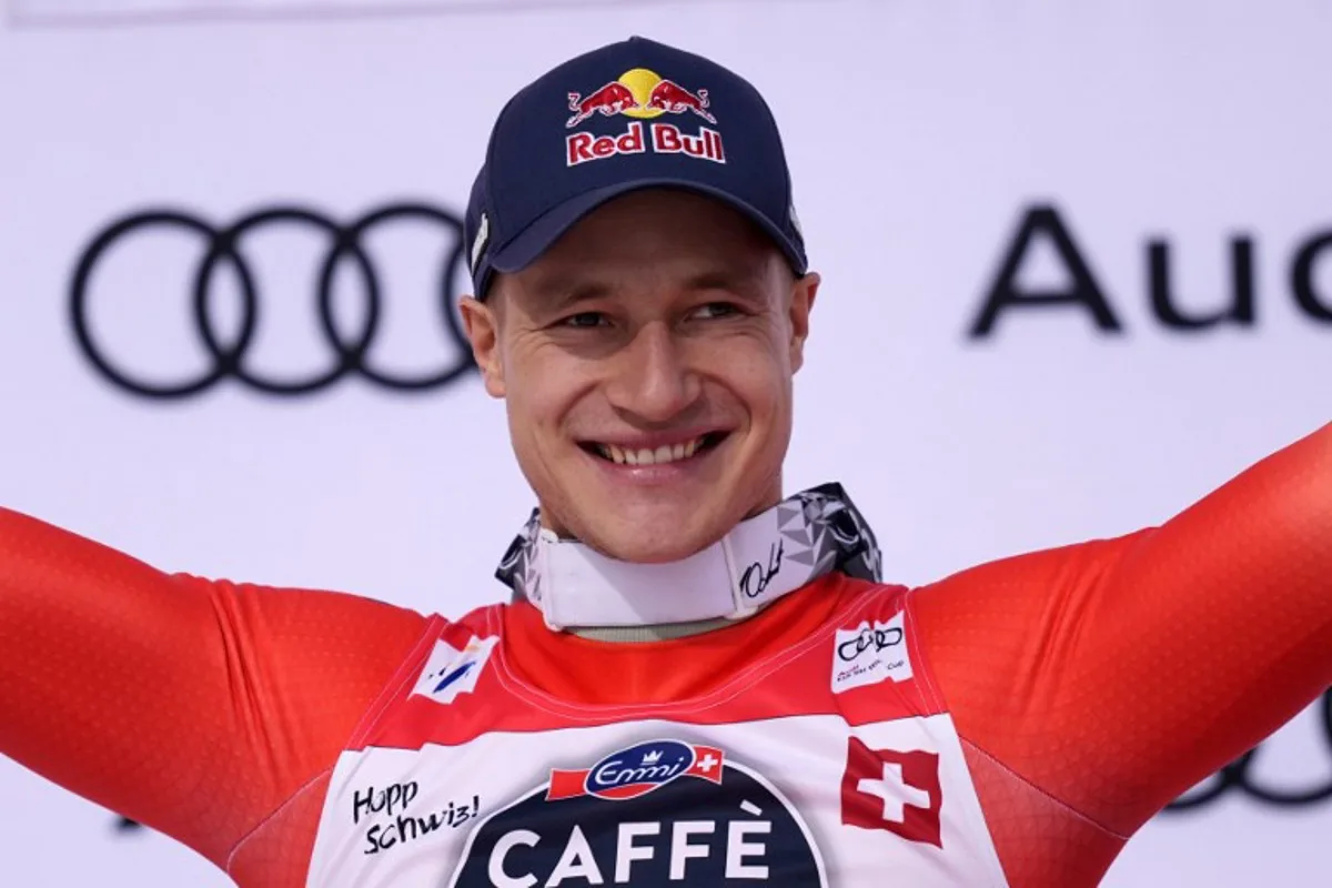 Second-placed Switzerland's Marco Odermatt celebrates on the podium after the men's downhill event at the FIS Alpine Skiing World Cup in Crans-Montana on February 22, 2025.  Maxime Schmid / AFP