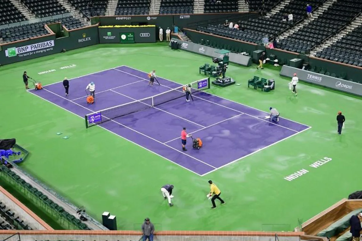 People dry the court in stadium 1 of Indian Wells during the rain delayed third round match between Coco Gauff of the US and Paula Badosa of Spain at ATP-WTA Indian Wells tennis tournament on October 11, 2021 in Indian Wells, California.  Frederic J. BROWN / AFP