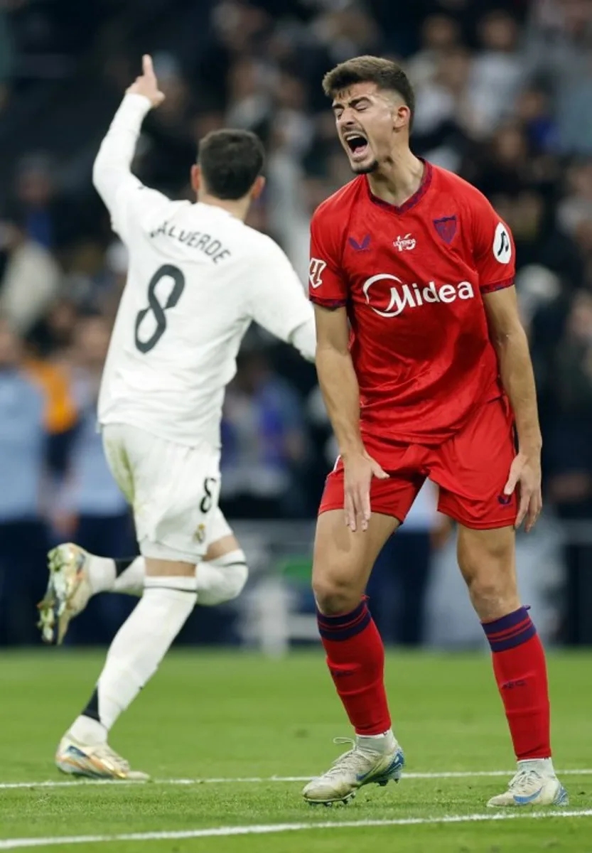 Sevilla's Spanish defender #04 Kike Salas reacts to Real Madrid's Uruguayan midfielder #08 Federico Valverde's goal during the Spanish league football match between Real Madrid CF and Sevilla FC at the Santiago Bernabeu stadium in Madrid on December 22, 2024.  OSCAR DEL POZO / AFP