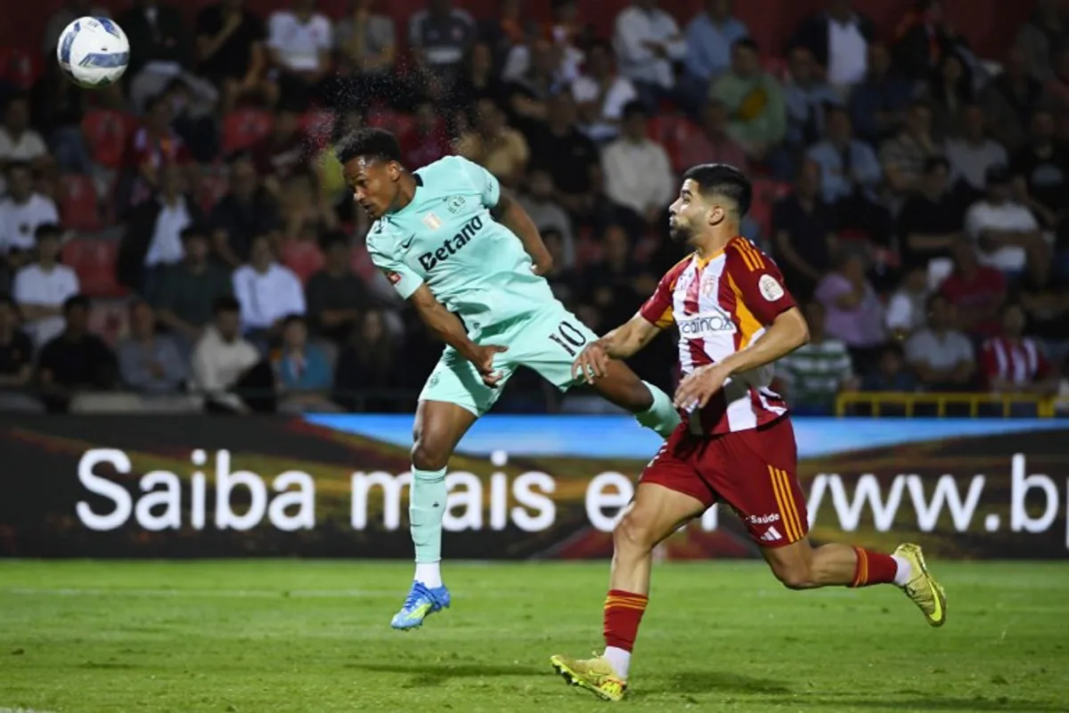Sporting Lisbon's Mozambican forward #10 Geny Catamo heads the ball next to AVS' Nigerian forward #11 Tunde Akinsola during the Portuguese League football match between AVS Futebol SAD and Sporting CP at CD Aves stadium in Vila das Aves on April 26, 2026. MIGUEL LEMOS / AFP