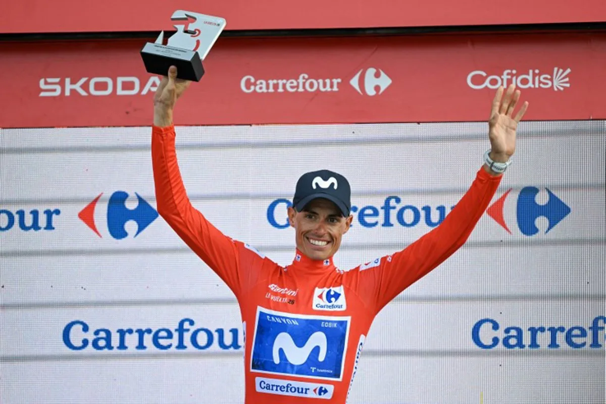 Overall race leader Team Movistar's Spanish rider Enric Mas celebrates retaining the race lead on the podium after the 14th stage of the Vuelta a Espana 2026 cycling tour, a 154,5 km race between Jaen and Sierra de la Pandera, on September 5, 2026. JORGE GUERRERO / AFP