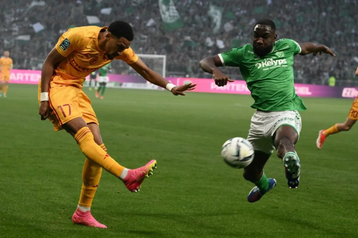 Rodez's Beninese forward #17 Andreas Hountondji (L) fights the ball with Saint-Etienne's French defender #03 Mickael Nade (R) during the French L2 play-off football match between Saint-Etienne and Rodez at The Geoffroy Guichard Stadium in Saint-Etienne, central-eastern France, on May 24, 2024.  JEAN-PHILIPPE KSIAZEK / AFP