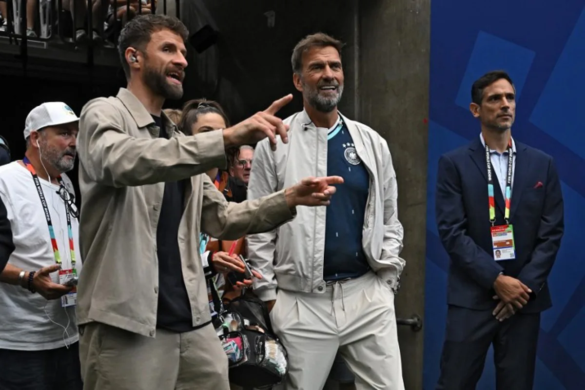 Former Liverpool head coach Jurgen Klopp (C) and former player Thomas Mueller (L) attend the 2026 World Cup Group E football match between Germany and Curacao at the Houston Stadium in Houston on June 14, 2026. Paul ELLIS / AFP