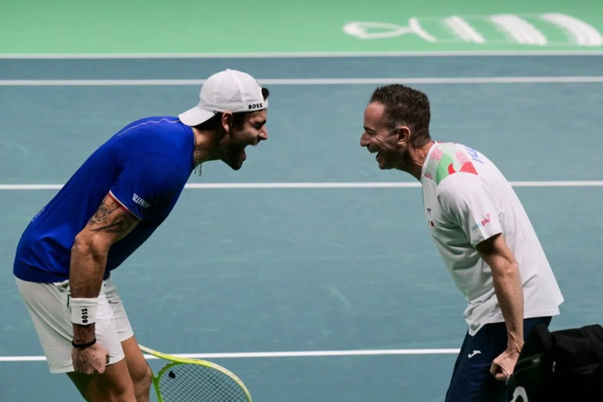 Italy's Matteo Berrettini (L) celebrates with Italy's coach Filippo Volandri after winning against Austria's Jurij Rodionov during their Davis Cup men's singles quarter finals tennis match, at the Super Tennis Arena, in Bologna, northen Italy, on November 19, 2025.  Tiziana FABI / AFP