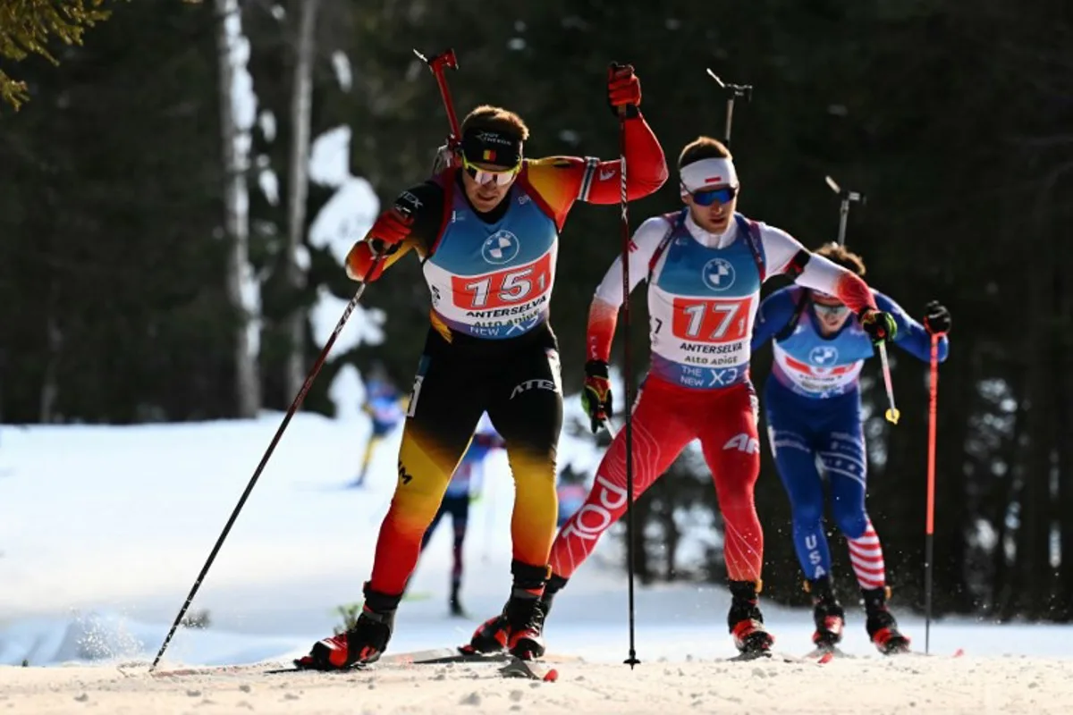 Poland's Konrad Badacz (C) and Belgium's Florent Claude (L) compete in the men's 7.5km relay event of the IBU Biathlon World Cup in Antholz-Anterselva, Italy, on January 25, 2025.  Marco BERTORELLO / AFP