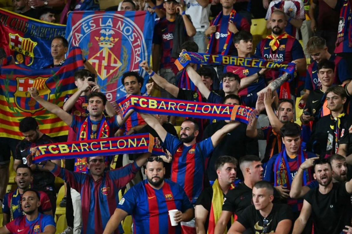 Barcelona´s supporters wave during the UEFA Champions League 1st round day 1 football match between AS Monaco and FC Barcelona at the Louis II Stadium in the Principality of Monaco on September 19, 2024.  Miguel MEDINA / AFP