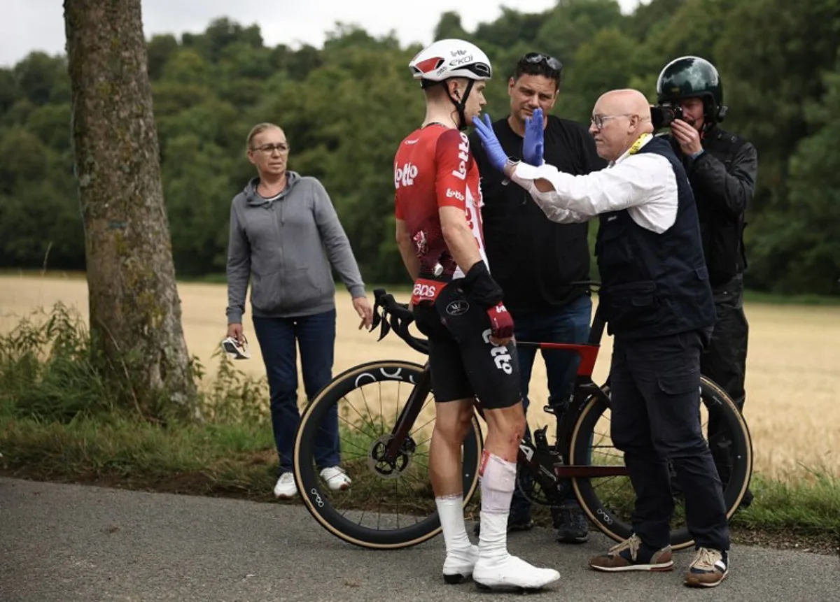 Lotto team's Belgian rider Lennert Van Eetvelt receives medical assistance after suffering a crash during the 2nd stage of the 112th edition of the Tour de France cycling race, 209.1 km between Lauwin-Planque and Boulogne-sur-Mer, Northern France, on July 6, 2025. Anne-Christine POUJOULAT / AFP