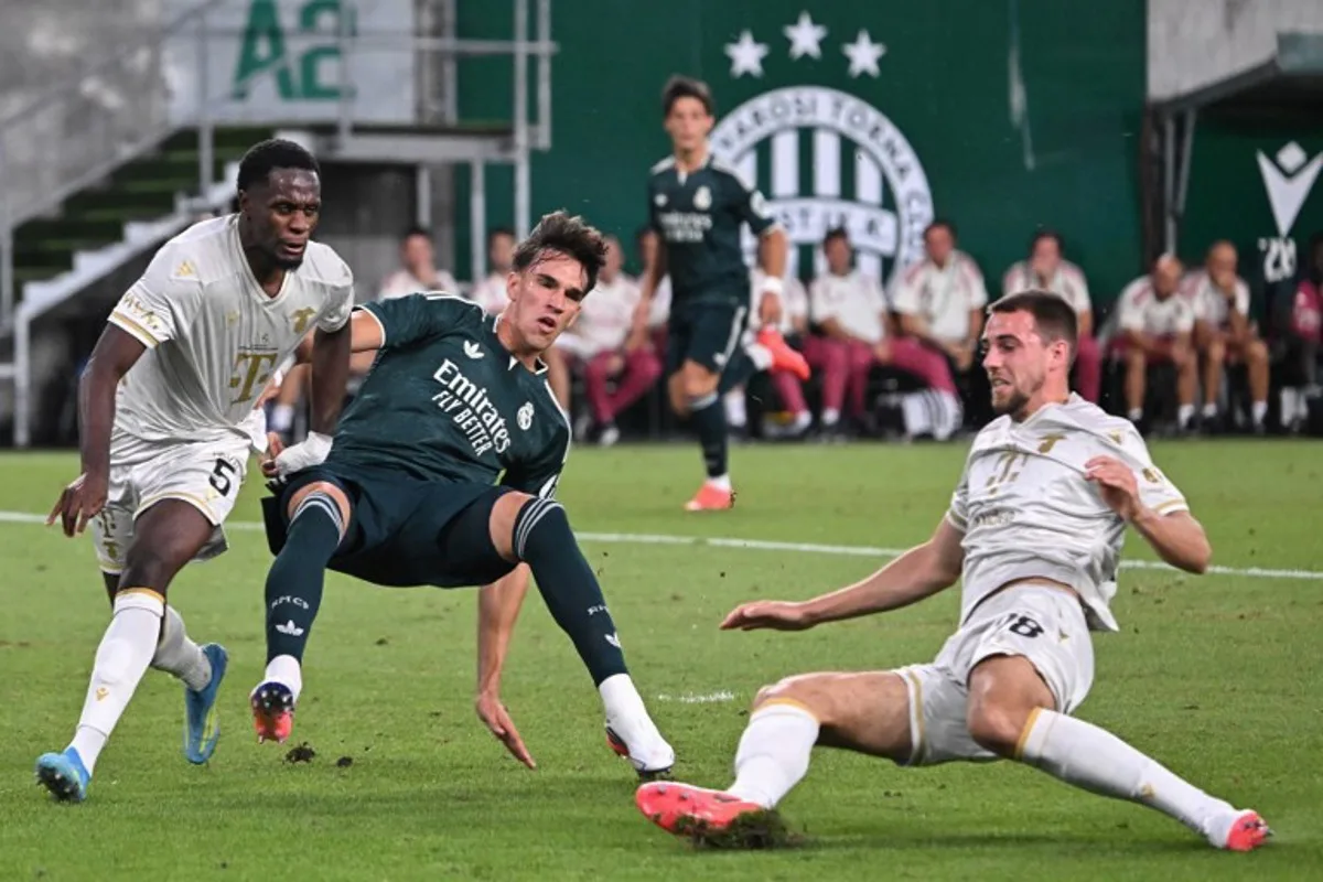 Real Madrid's Spanish forward #40 Carlos Espi (C), Ferencvaros' French defender #05 Nathan Zohore (L) and Ferencvaros' Belgian defender #28 Toon Raemaekers vie for the ball during the pre-season football match between Ferencvaros and Real Madrid in Budapest, Hungary on August 8, 2026. Real Madrid on August 6, 2026 announced a new six-year deal for star forward Vinicius Junior and the signing of teenage sensation Yan Diomande in a major boost to their quest to end a two-year trophy drought. Attila KISBENEDEK / AFP