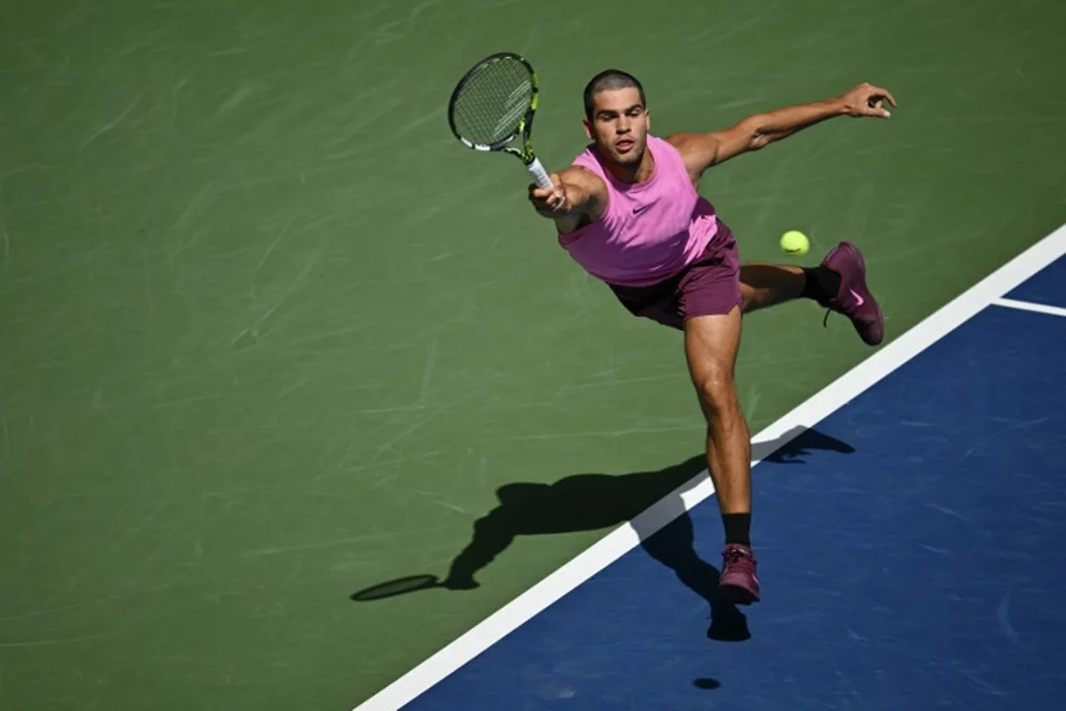 Spain's Carlos Alcaraz hits a return to France's Arthur Rinderknech during their men's singles round of 16 tennis match on day eight of the US Open tennis tournament at the USTA Billie Jean King National Tennis Center in New York City, on August 31, 2025. ANGELA WEISS / AFP
