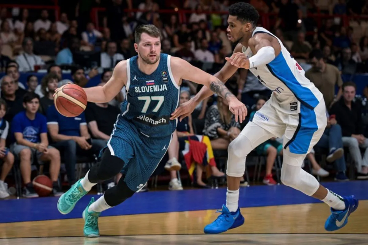 Slovenia's Luka Doncic (L) is marked by Greece's Giannis Antentokoumpo during the 2024 FIBA Olympic Qualifying Tournament semi-final basketball match between Greece and Slovenia at the Peace and Friendship Stadium in Athens, on July 6, 2024.  Aris MESSINIS / AFP