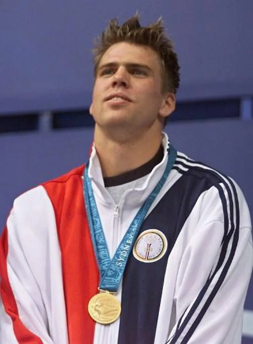 US swimmers Gary Hall Jr. displays his gold medal after winning ex-aequo with compatriot Anthony Erwin the men's 50m freestyle event 22 September 2000 at Sydney International Aquatics centre during Sydney 2000 summer olympics. Pieter Van Hoogenband of the Netherlands finished second and won the bronze. AFP PHOTO/GREG WOOD