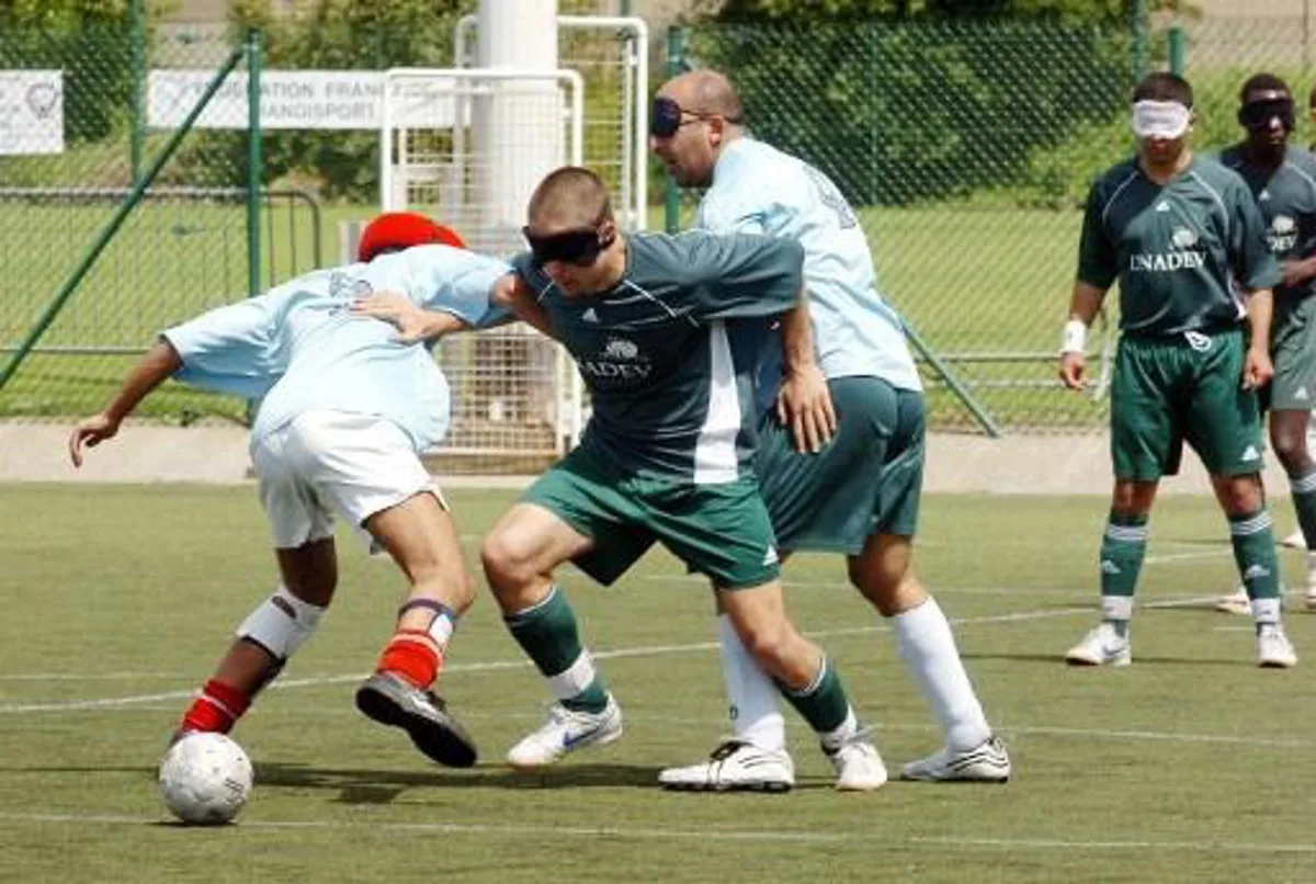 POUR ILLUSTRER LE PAPIER: LES NON-VOYANTS JOUENT AUSSI AU FOOTBALL ET SE DISPUTENT LEUR COUPE DE FRANCE. Un joueur de l'équipe bordelaise UNADEV (C) tente d'échapper à deux défenseurs de l'équipe des Lyonnais Guinot Villejuif, lors d'un match de Coupe de France pour non-voyants, Cécifoot, le 12 mai 2007 au stade la Cavée verte au Havre. Le cécifoot est l'adaptation du football pour les aveugles, les dimensions du terrain y sont plus réduites (50m x 25m), les équipes ne comptent que cinq joueurs de champ et les périodes sont de 20 minutes pour les mal voyants et de 25 minutes pour les non-voyants.   AFP PHOTO ROBERT FRANCOIS  ROBERT FRANCOIS / AFP