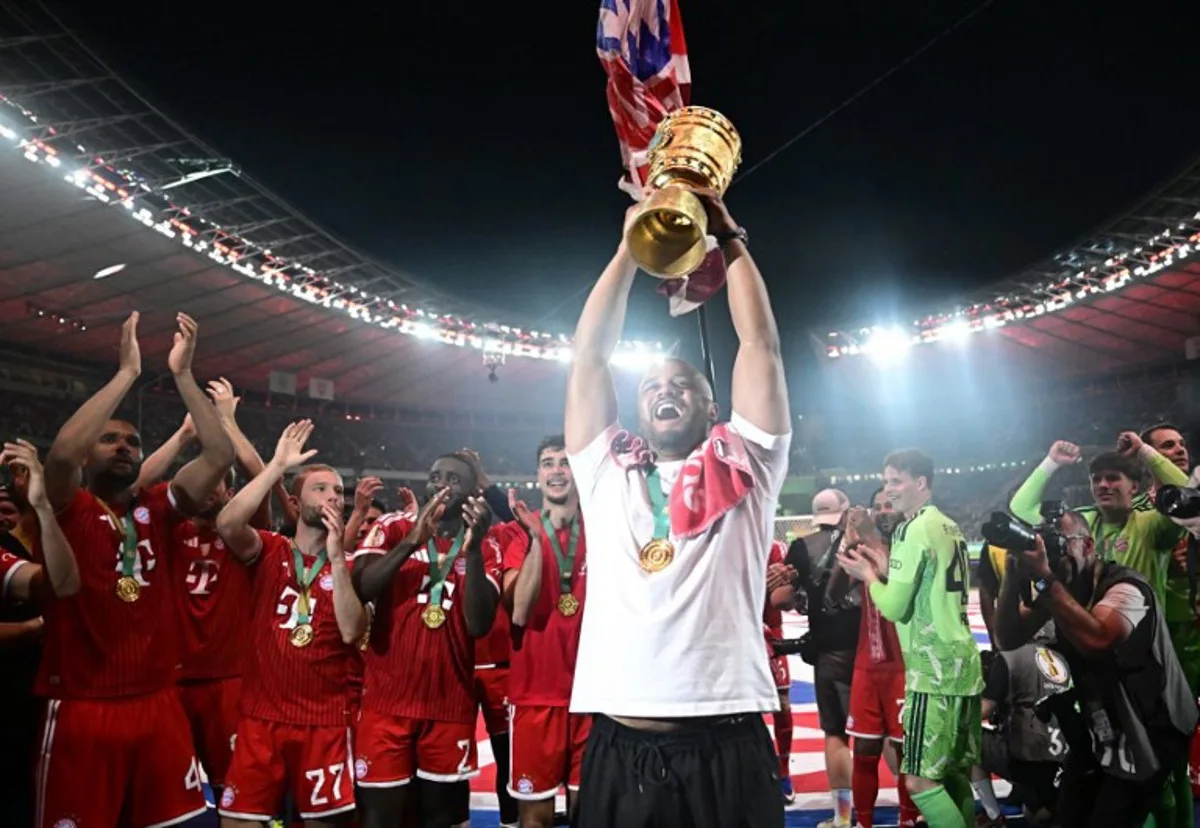 Bayern Munich's Belgian head coach Vincent Kompany lifts the trophy after the German Cup (DFB Pokal) final football match FC Bayern Munich v VfB Stuttgart at the Olympic Stadium in Berlin, on May 23, 2026. Tobias SCHWARZ / AFP