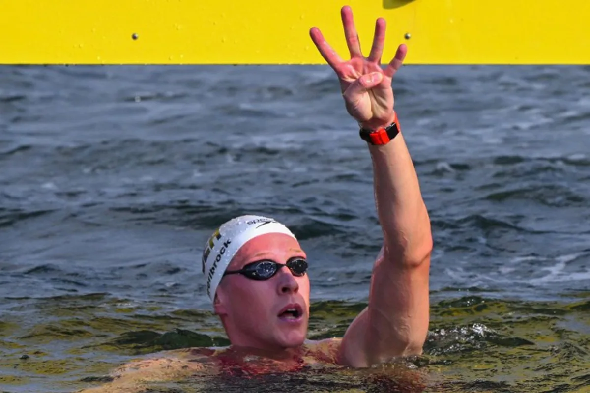 Germany's swimmer Florian Wellbrock celebrates after winning the final of the mixed 4x1500m relay open water swimming event during the 2025 World Aquatics Championships at Sentosa Island in Singapore on July 20, 2025. François-Xavier MARIT / AFP