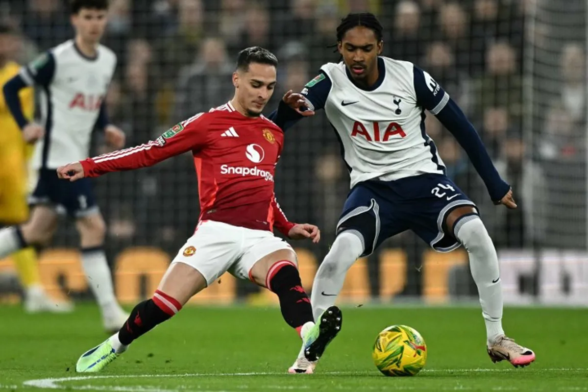 Manchester United's Brazilian midfielder #21 Antony (L) vies with Tottenham Hotspur's English defender #24 Djed Spence during the English League Cup quarter-final football match between Tottenham Hotspur and Manchester United at the Tottenham Hotspur Stadium in London, on December 19, 2024.  Ben STANSALL / AFP