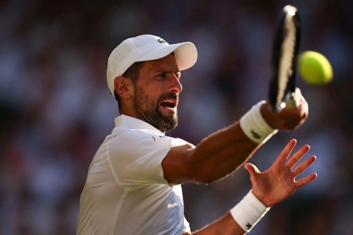 Serbia's Novak Djokovic plays a forehand return to Italy's Jannik Sinner during their men's singles semi-final tennis match on the twelfth day of the 2025 Wimbledon Championships at The All England Lawn Tennis and Croquet Club in Wimbledon, southwest London, on July 11, 2025. HENRY NICHOLLS / AFP