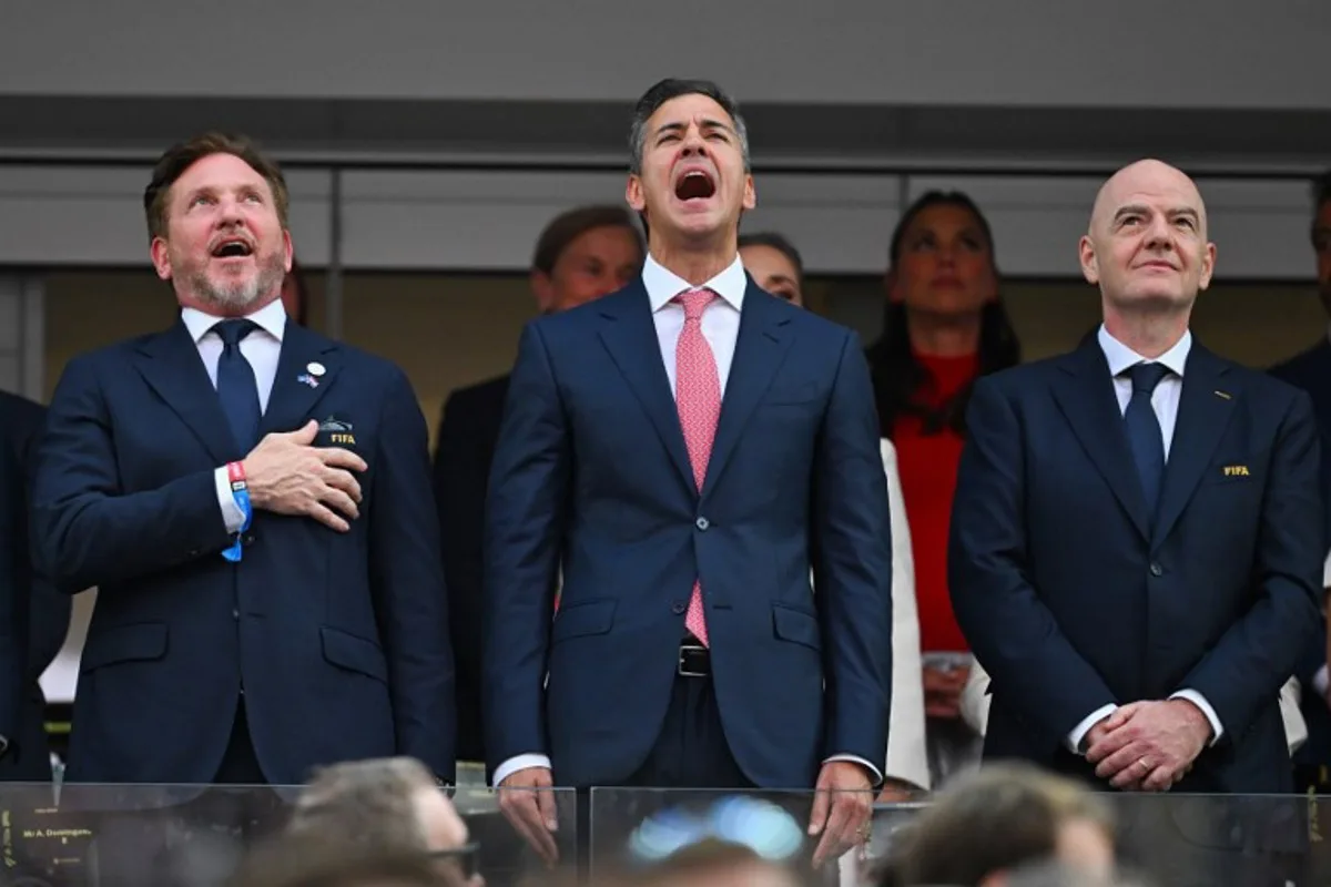(L-R) CONMEBOL President Alejandro Dominguez and Paraguayan President Santiago Pena sing the Paraguayan national anthem next to FIFA president Gianni Infantino ahead of the 2026 World Cup Group D football match between USA and Paraguay at the Los Angeles Stadium in Inglewood on June 12, 2026. Patrick T. Fallon / AFP