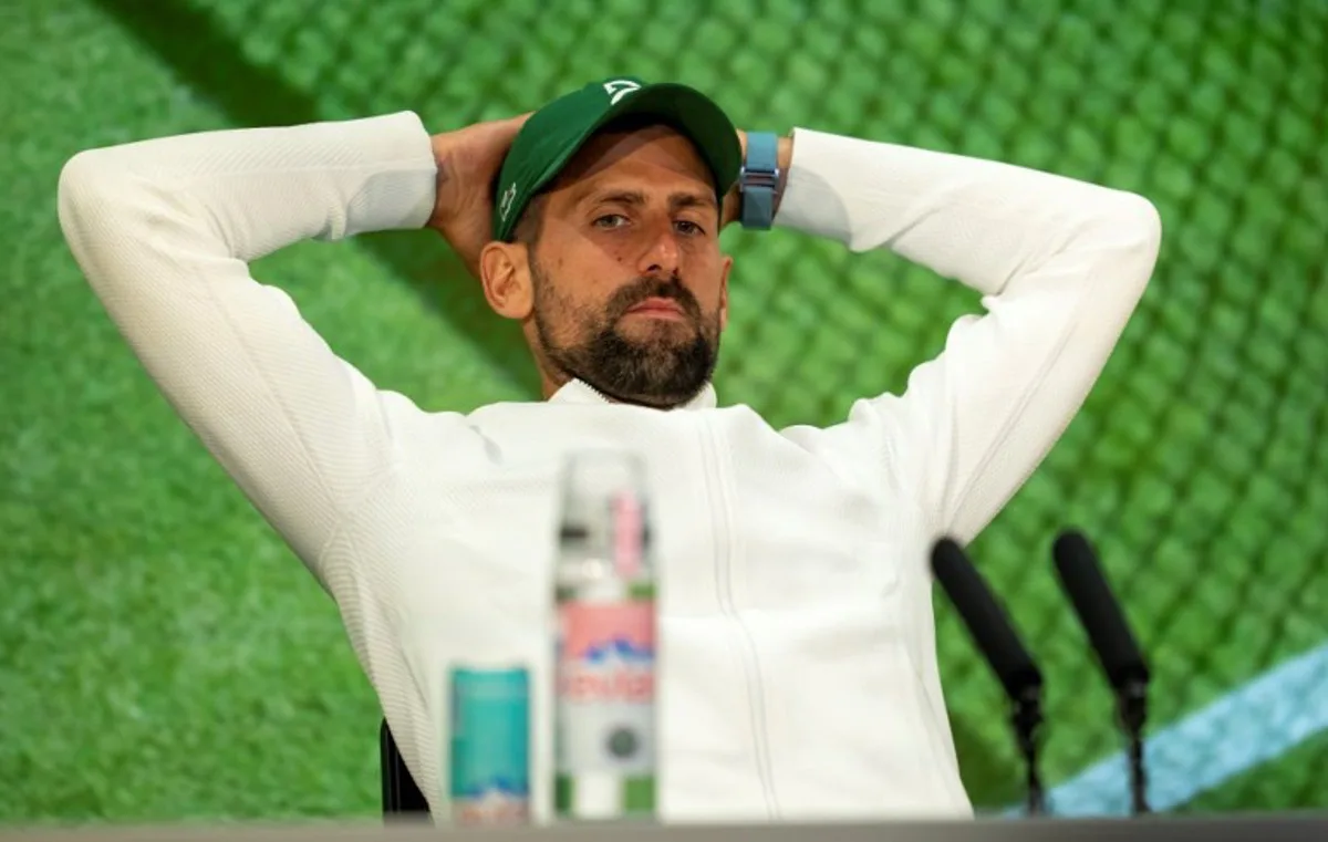 Serbia's Novak Djokovic reacts as he speaks to the media during a post-match press conference in the Media Theatre in the Broadcast Centre after his defeat in the men's singles semi-final tennis match against Italy's Jannik Sinner on the twelfth day of the 2025 Wimbledon Championships at The All England Lawn Tennis and Croquet Club in Wimbledon, southwest London, on July 11, 2025. Benjamin Gilbert / AELTC / POOL / AFP