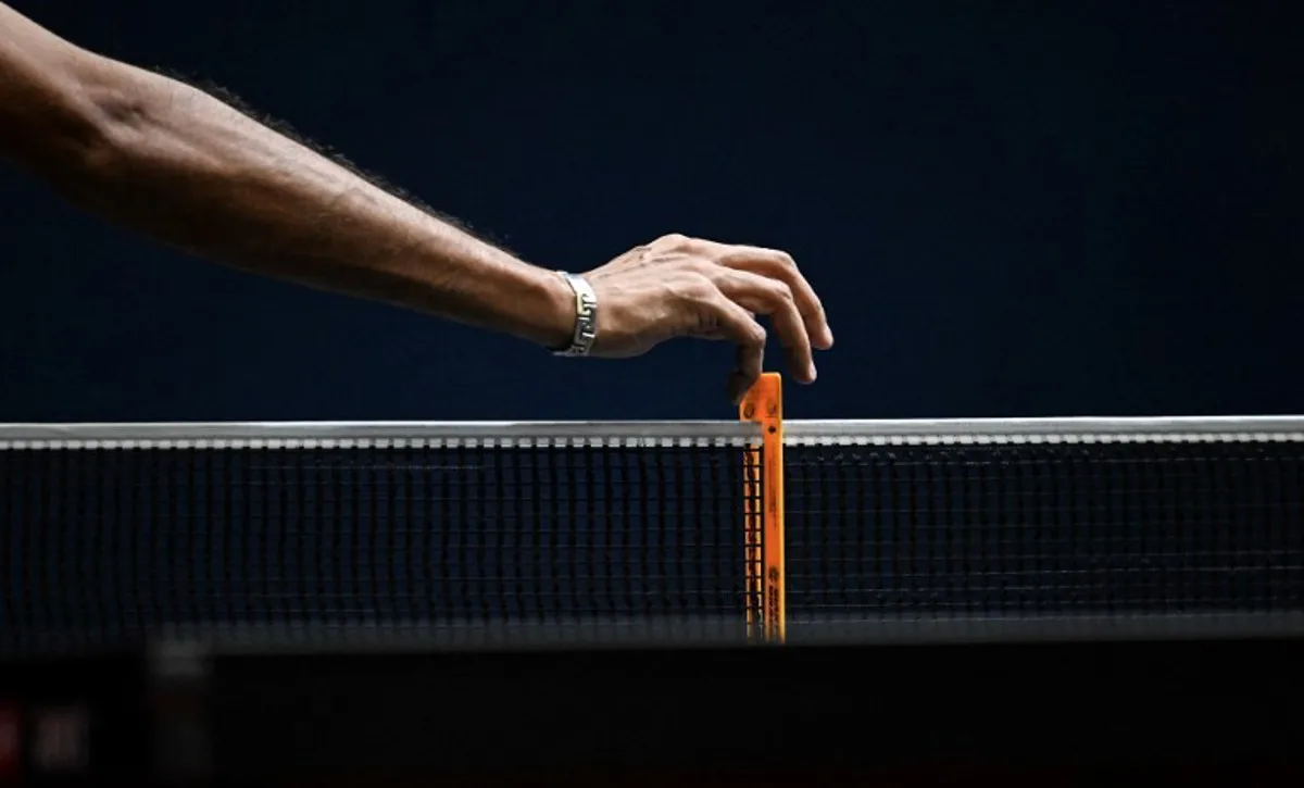 An umpire checks the height of a net during the World Table Tennis (WTT) Feeder Series at Popper & Lopez Sports Center in Caracas on November 2, 2024.  Juan BARRETO / AFP