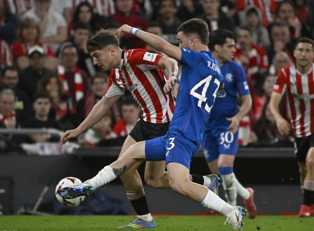 Athletic Bilbao's Spanish midfielder #23 Mikel Jauregizar Alboniga fights for the ball with Rangers' Belgian midfielder #43 Nicolas Raskin during the UEFA Europa League quarter final second leg football match between Athletic Club Bilbao and Glasgow Rangers, at the San Mames stadium in Bilbao on April 17, 2025. ANDER GILLENEA / AFP