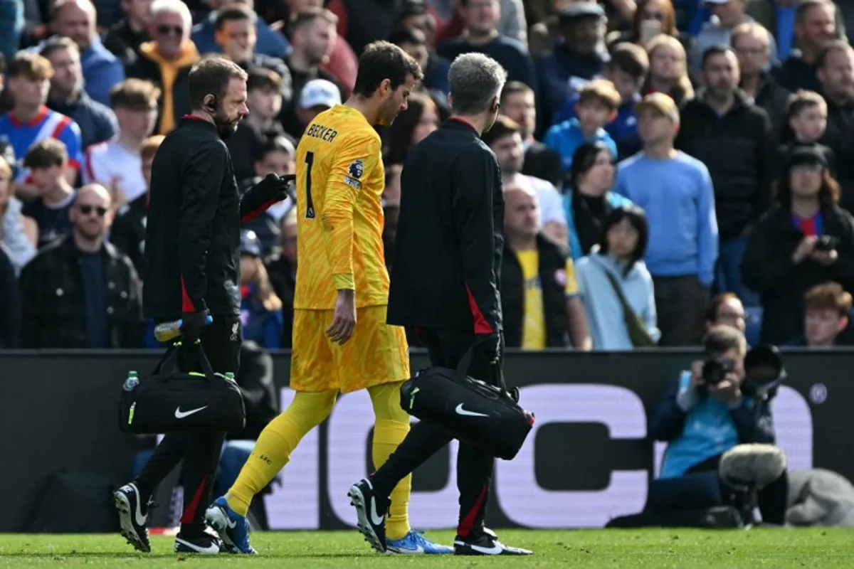 Liverpool's Brazilian goalkeeper #01 Alisson Becker leaves the game after picking up an injury during the English Premier League football match between Crystal Palace and Liverpool at Selhurst Park in south London on October 5, 2024.  Glyn KIRK / AFP