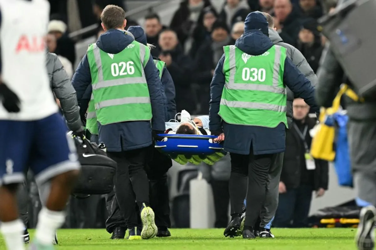 An injured Tottenham Hotspur's Uruguayan midfielder #30 Rodrigo Bentancur lays on a stretcher as he is carried off of the pitch during the English League Cup semi-final first leg football match between Tottenham Hotspur and Liverpool at the Tottenham Hotspur Stadium in London, on January 8, 2025.  JUSTIN TALLIS / AFP