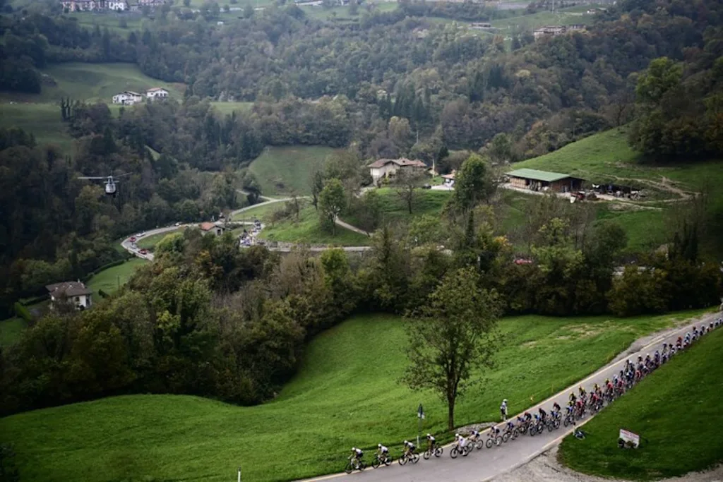 The pack of riders (peloton) cycles in the Zambla Alta ascent during the 119th edition of the Giro di Lombardia (Tour of Lombardy), a 238km cycling race from Como to Bergamo on October 11, 2025. Marco BERTORELLO / AFP