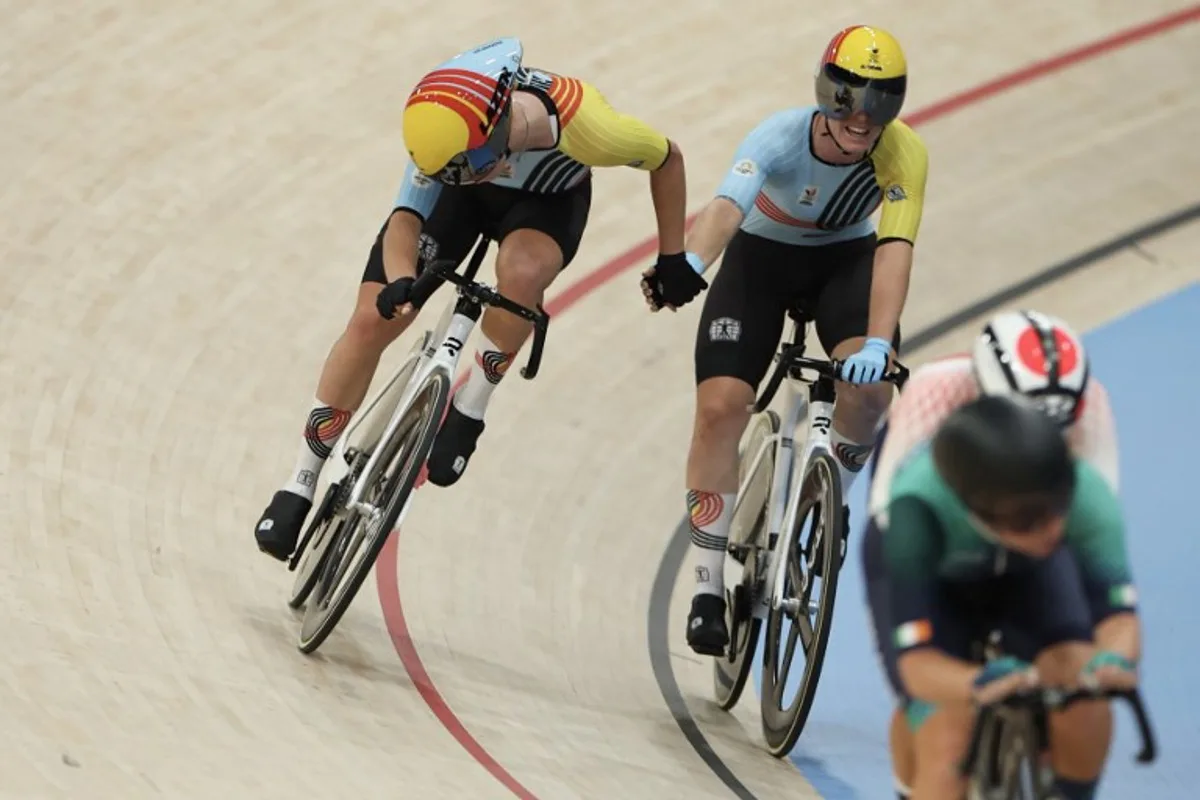 Belgium's Katrijn De Clercq relays Belgium's Helene Hesters during the women's track cycling madison final of the Paris 2024 Olympic Games at the Saint-Quentin-en-Yvelines National Velodrome in Montigny-le-Bretonneux, south-west of Paris, on August 9, 2024.  Thomas SAMSON / AFP