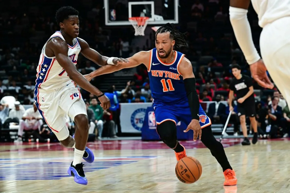 New York Knicks' #11 Jalen Brunson dribbles against Philadelphia 76ers' #77 VJ Edgecombe during the NBA basketball game between the New York Knicks and the Philadelphia 76ers at the Etihad Arena in Abu Dhabi on October 2, 2025. Giuseppe CACACE / AFP