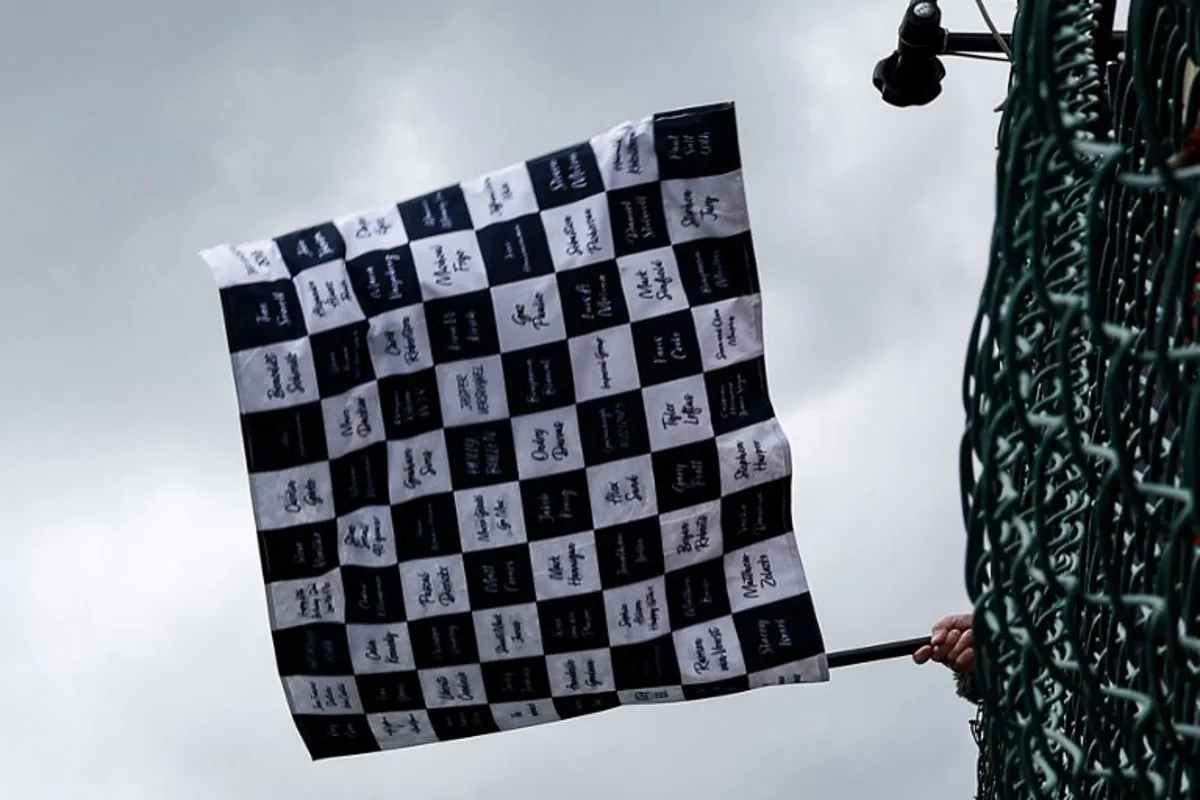 A race marshal waves the checkered flag at the end of the Formula One Belgian Grand Prix at the Spa-Francorchamps Circuit in Spa on July 30, 2023. SIMON WOHLFAHRT / POOL / AFP