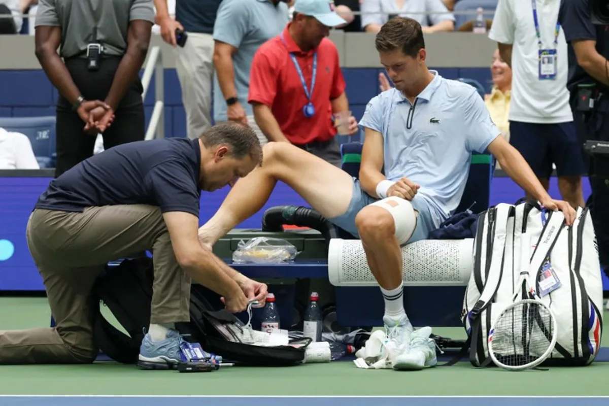 Belgium's Alexander Blockx receives medical attention as he plays Russia's Karen Khachanov in their men's singles quarter-final tennis match on day eleven of the US Open tennis tournament at the USTA Billie Jean King National Tennis Center in New York on September 9, 2026. TIMOTHY A. CLARY / AFP