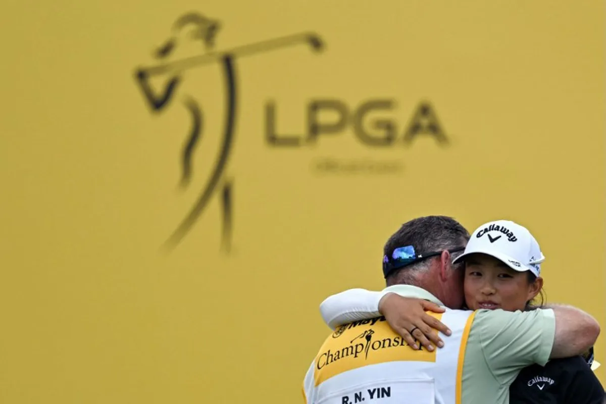 China's Yin Ruoning (R) celebrates with her caddie David Jones (L) after her victory in the final round of the LPGA Maybank Championship golf tournament at the Kuala Lumpur Golf and Country Club in Kuala Lumpur on October 27, 2024.  Mohd RASFAN / AFP