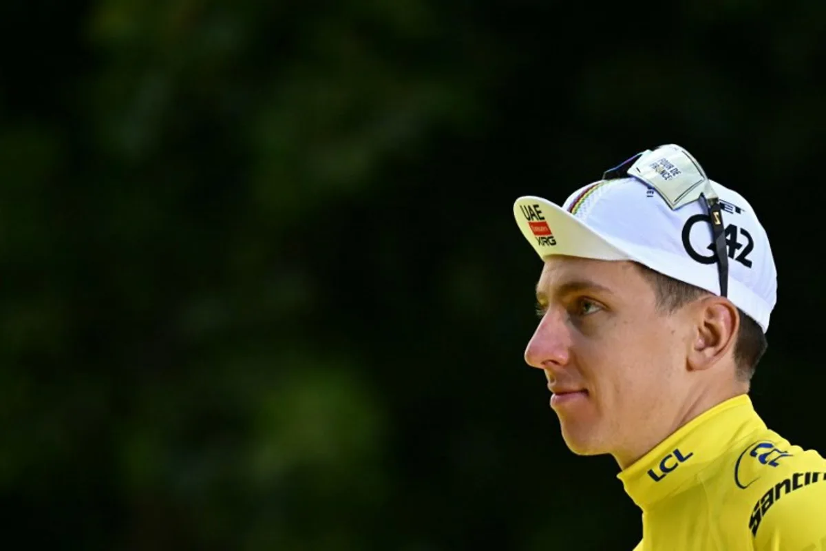 UAE Team Emirates - XRG team's Slovenian rider Tadej Pogacar celebrates on the podium with the overall leader's yellow jersey after the 21st and final stage of the 112th edition of the Tour de France cycling race, 132.3 km between Mantes-la-Ville and Paris Champs-Élysees, on July 27, 2025. Loic VENANCE / AFP