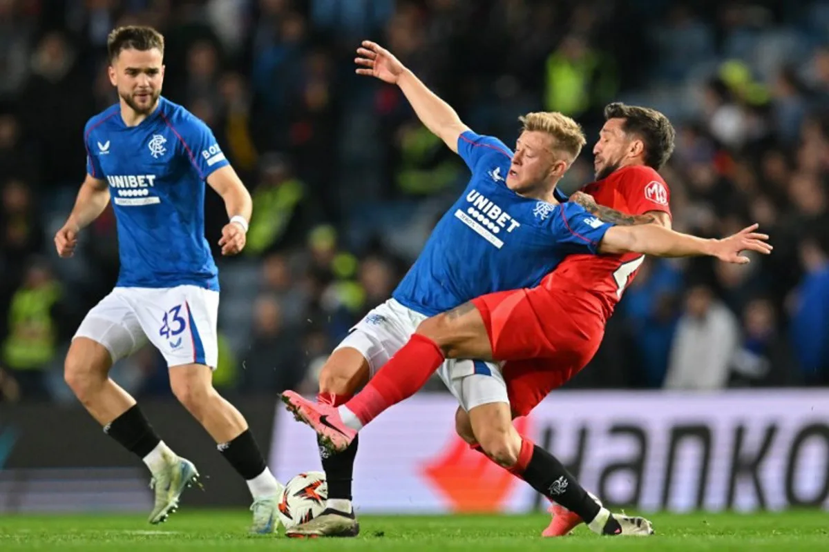 Rangers' Scottish midfielder #08 Connor Barron (C) vies with Steaua Bucharest's Romanian midfielder #25 Alexandru Baluta (R) during the UEFA Europa League, League stage day 3 football match between Rangers and FCSB at the Ibrox Stadium in Glasgow on October 24, 2024.  ANDY BUCHANAN / AFP