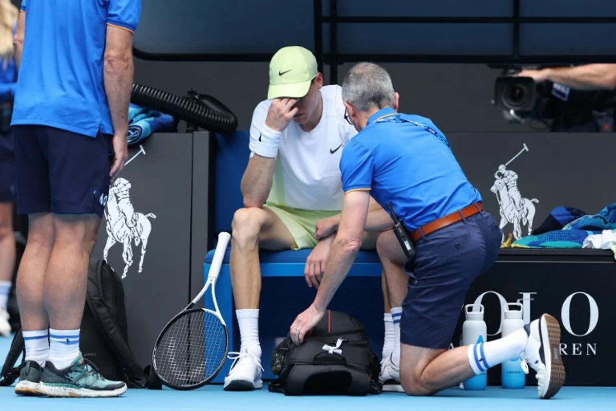 Italy's Jannik Sinner has a medical timeout whilst playing against Denmark's Holger Rune during their men's singles match on day nine of the Australian Open tennis tournament in Melbourne on January 20, 2025.  Martin KEEP / AFP