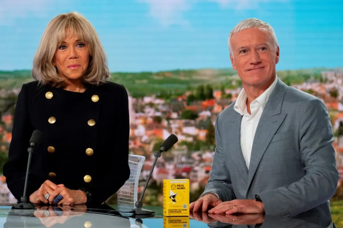 French President's wife Brigitte Macron (L) and French national football team's head coach Didier Deschamps pose as they sit on the set of French TV channel TF1 for a pre-recording of a segment of the daily news show "Le 13h", in Boulogne-Billancourt, west of Paris, on January 6, 2025. Brigitte Macron and Didier Deschamps are the star figures launching the 2025 edition of the charity fund called "Operations pieces jaunes" (operation yellow coins), with its foundation aiming to improve the conditions of hospitalized children. Martin LELIEVRE / AFP