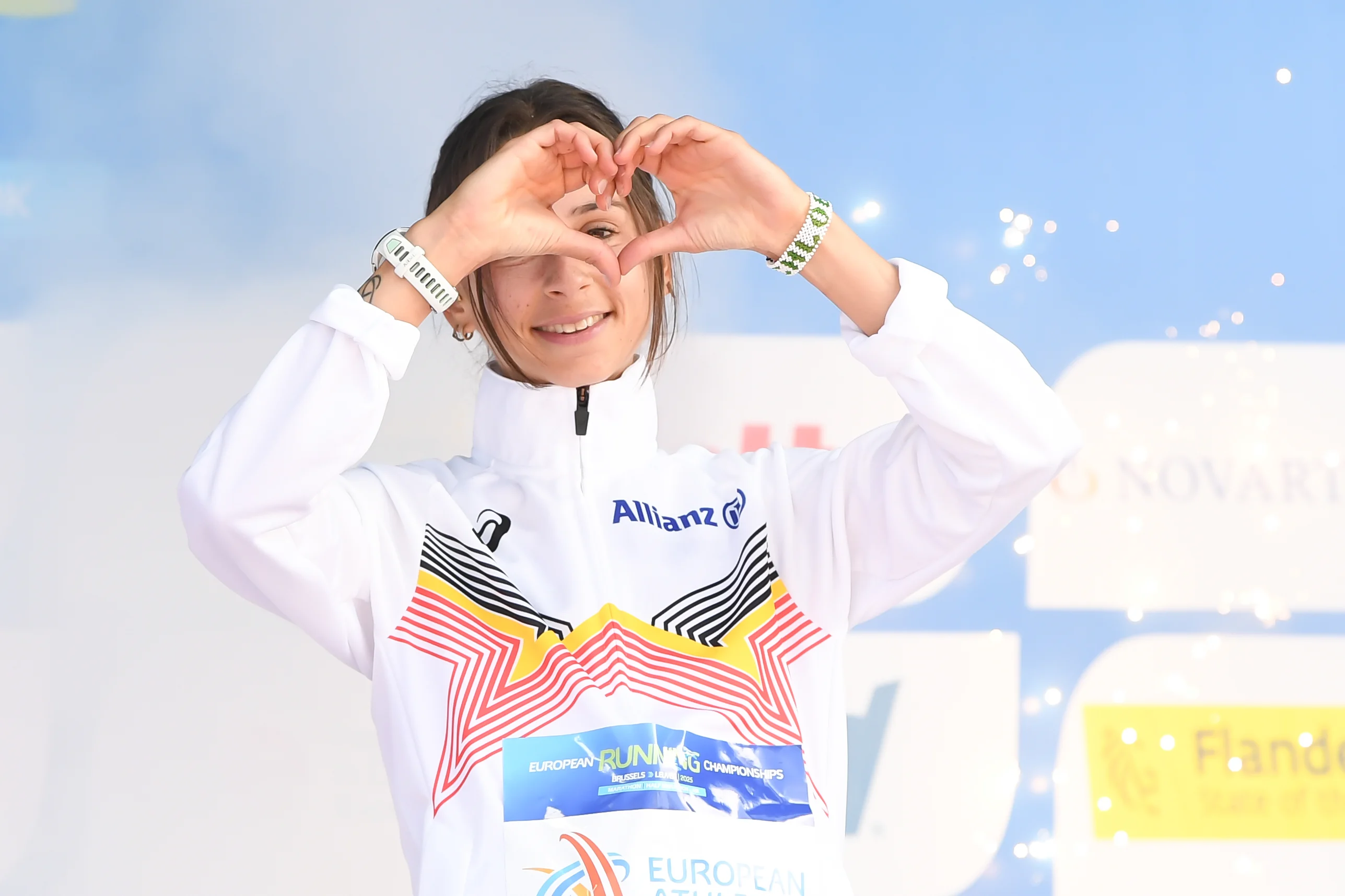 Belgian Chloe Herbiet celebrates on the podium after winning the half marathon race at European Running Championships, in Leuven, Saturday 12 April 2025. BELGA PHOTO JILL DELSAUX