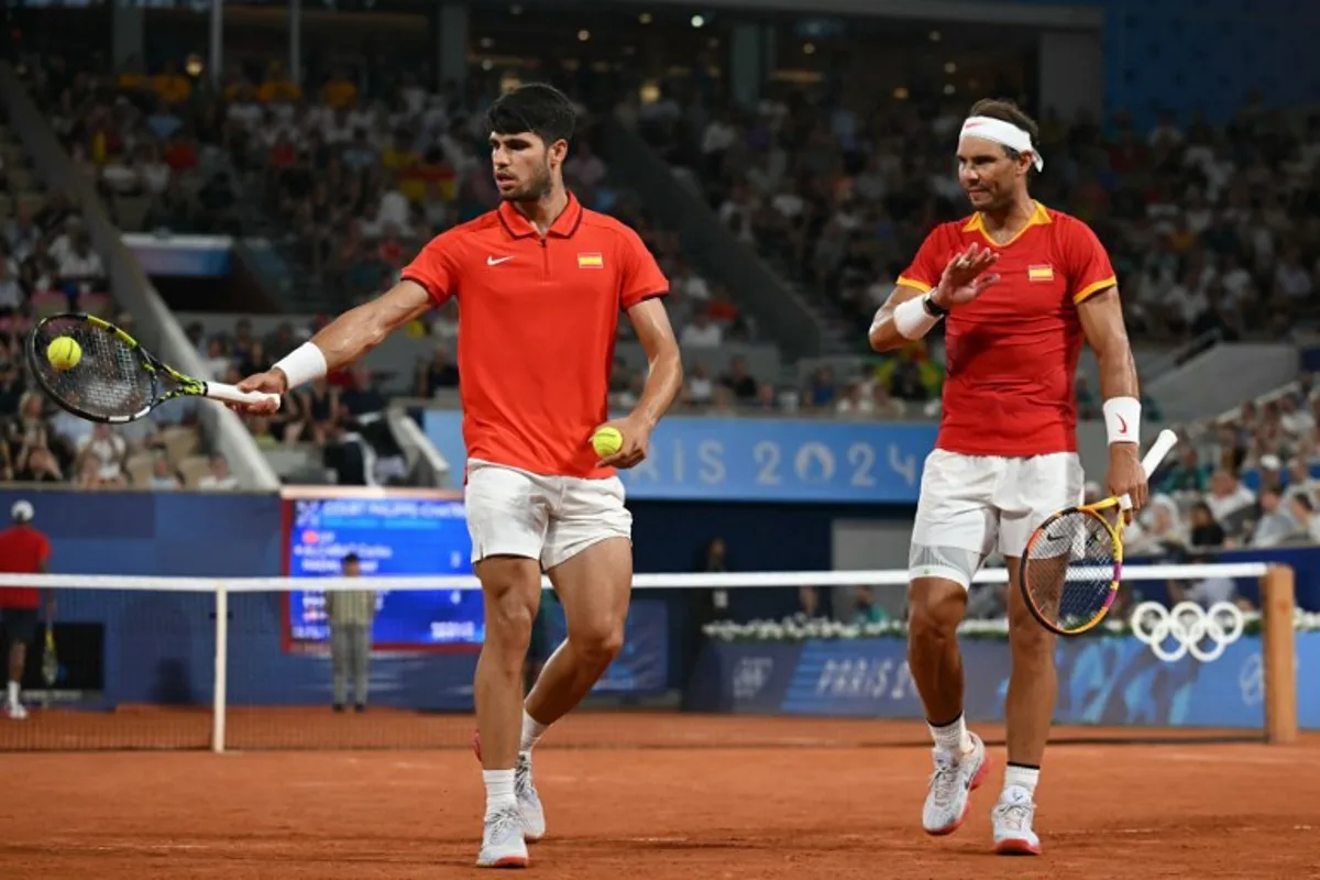 Spain's Rafael Nadal (R) and Spain's Carlos Alcaraz (L) play US' Austin Krajicek and US' Rajeev Ram during their men's doubles quarter-final tennis match on Court Philippe-Chatrier at the Roland-Garros Stadium during the Paris 2024 Olympic Games, in Paris on July 31, 2024.   CARL DE SOUZA / AFP