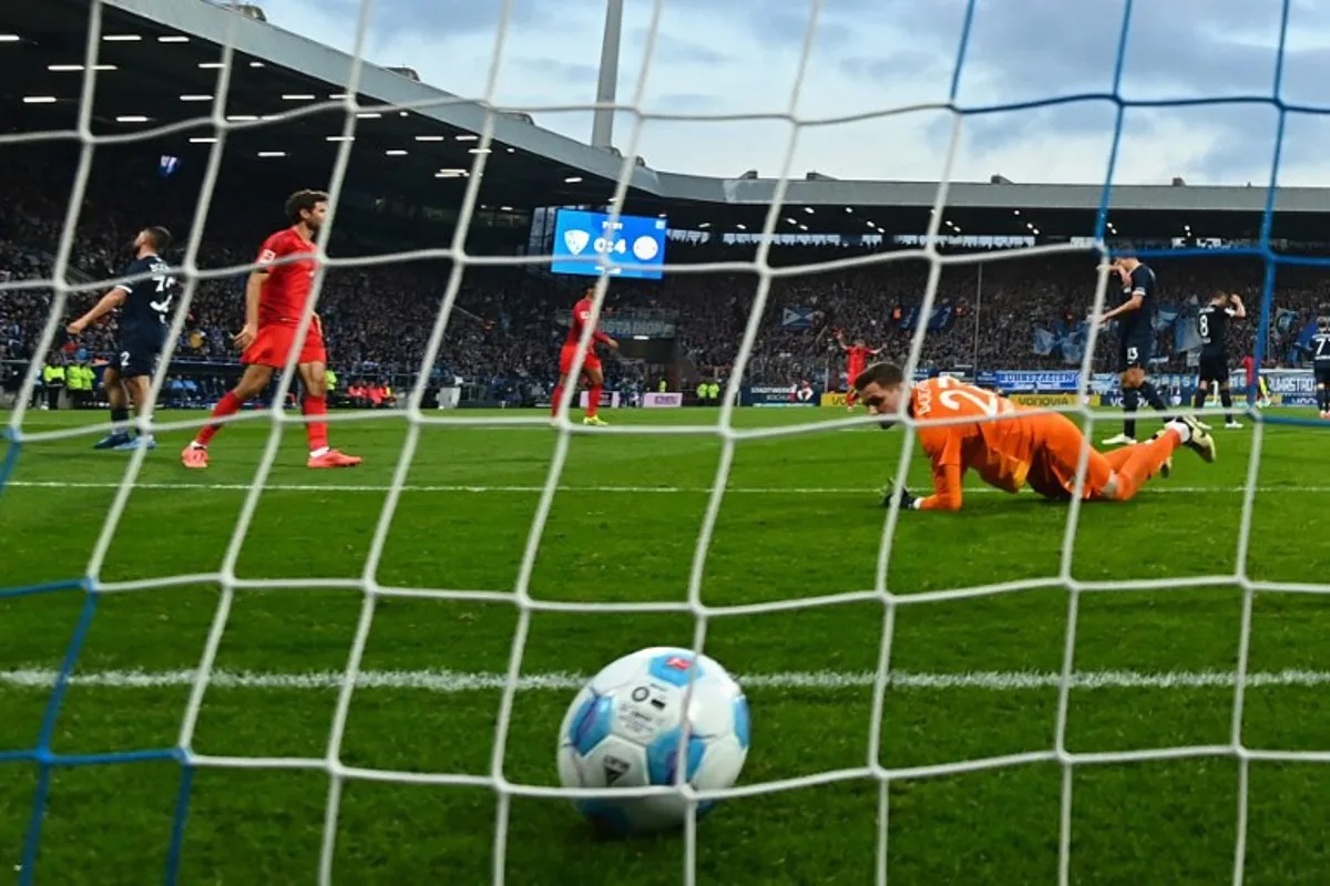 Bochum's German goalkeeper #27 Patrick Drewes fails to save the 0-5 goal during the German first division Bundesliga football match between VfL Bochum and FC Bayern Munich in Bochum, western Germany, on October 27, 2024.  Ina Fassbender / AFP