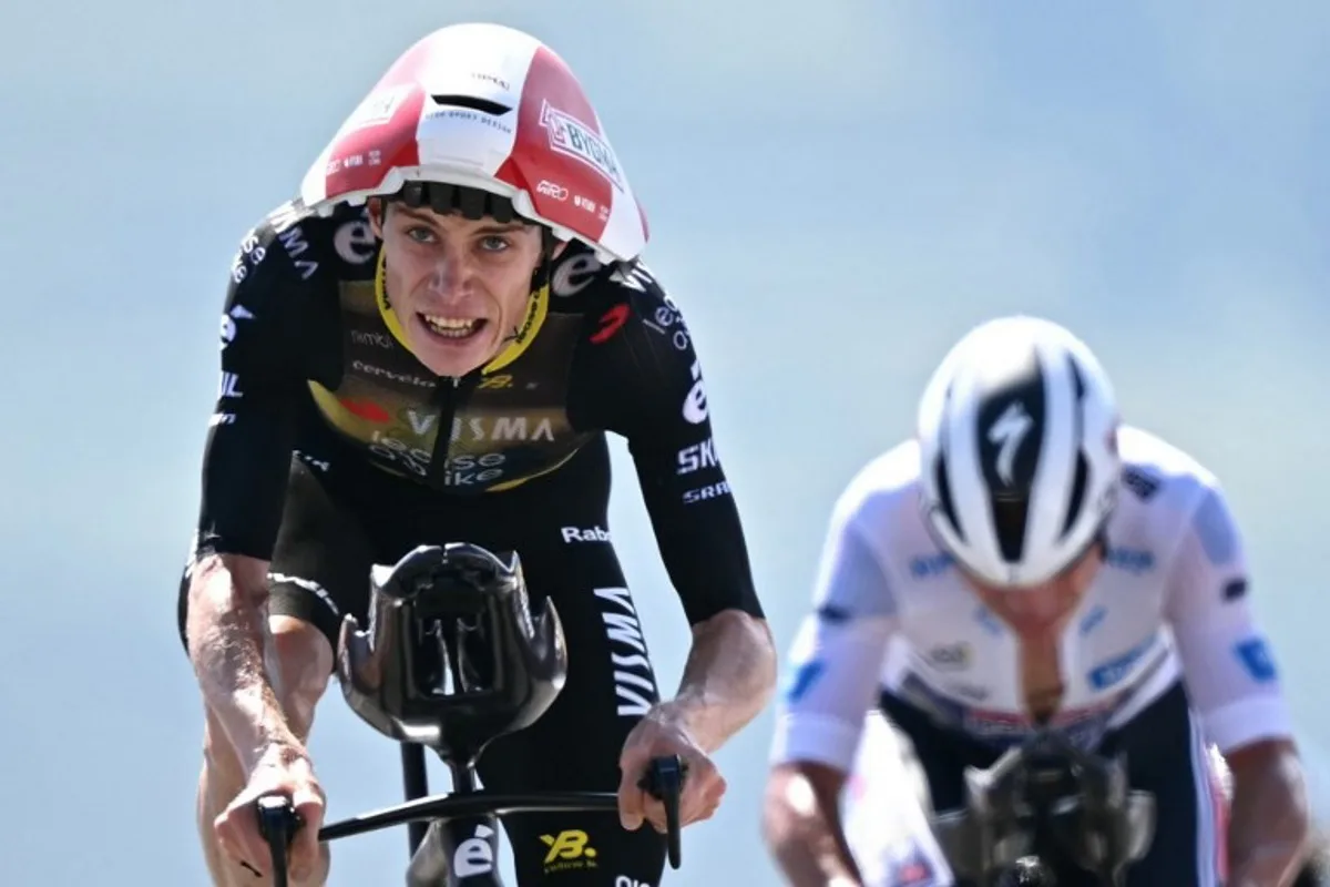 Team Visma - Lease a bike team's Danish rider Jonas Vingegaard cyles past Soudal Quick-Step team's Belgian rider Remco Evenepoel metres from the finish line of the 13th stage of the 112th edition of the Tour de France cycling race, 10.9 km individual time trial between Loudenvielle and Peyragudes, in the Pyrenees mountains of southwestern France, on July 18, 2025. Loic VENANCE / AFP
