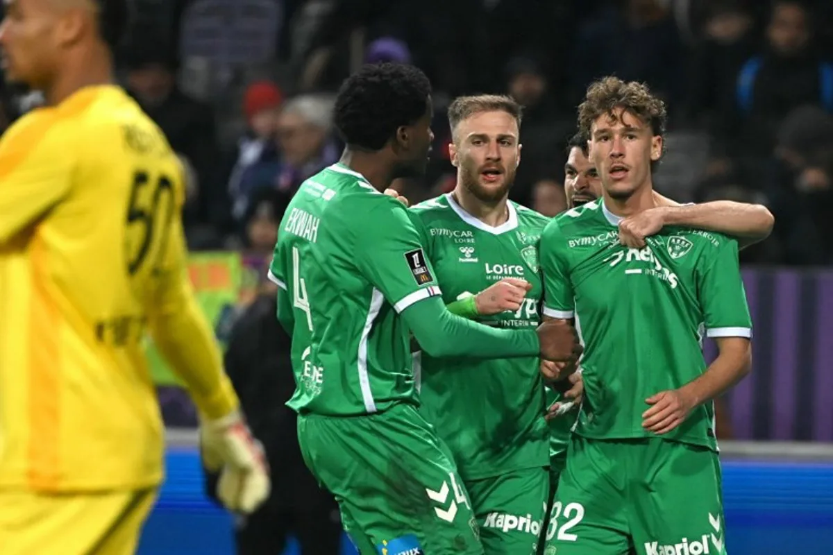 Saint Etienne's Belgian forward #32 Lucas Stassin (R) is congratulated by teammates after scoring Saint Etienne's first goal during the French L1 football match between Toulouse FC and AS Saint-Etienne at the TFC Stadium in Toulouse, southwestern France, on December 13, 2024.  Matthieu RONDEL / AFP