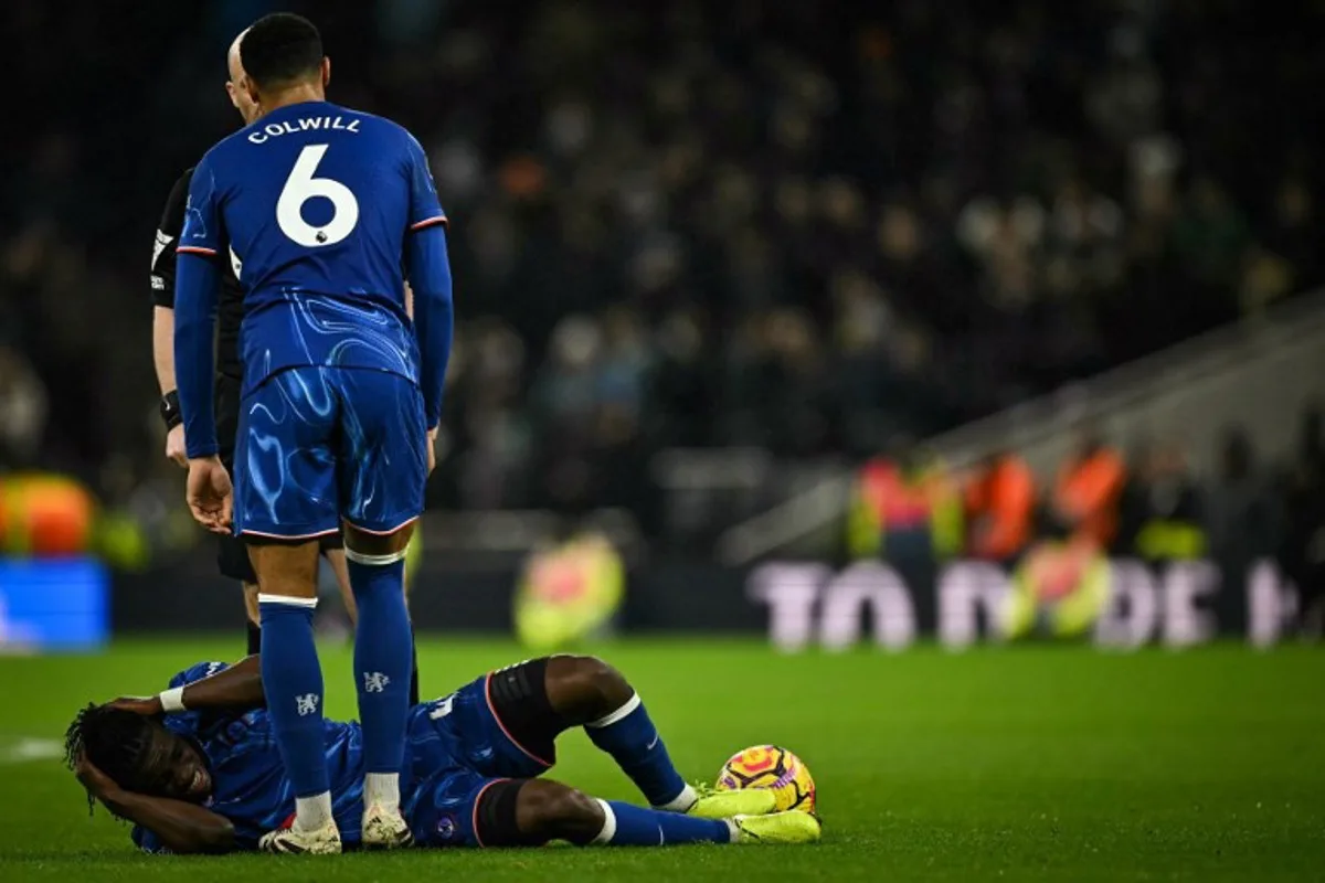 Chelsea's Belgian midfielder #45 Romeo Lavia (down) reacts after being hurt during the English Premier League football match between Tottenham Hotspur and Chelsea at the Tottenham Hotspur Stadium in London, on December 8, 2024.  Ben STANSALL / AFP