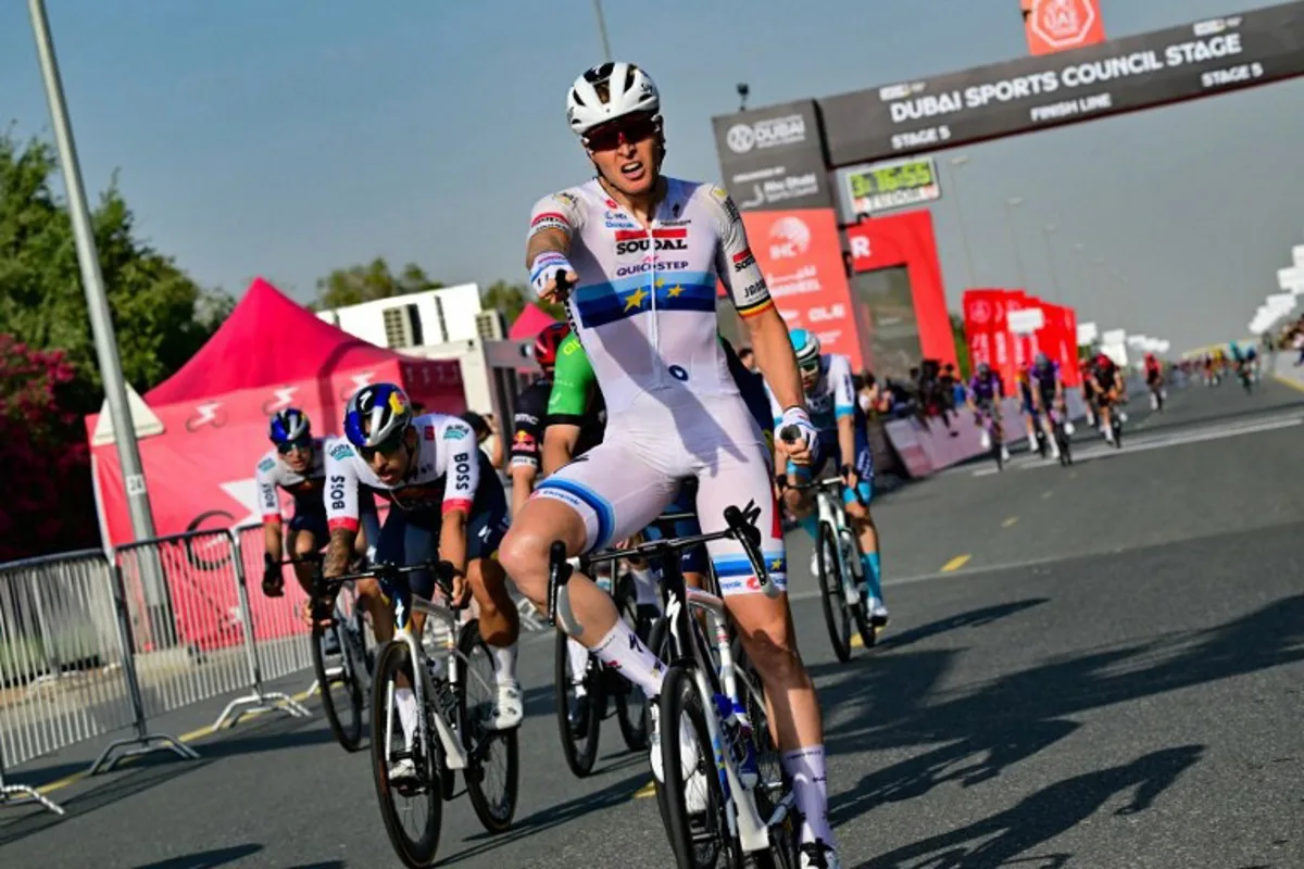 Team Soudal Quick-Step Belgian rider Tim Merlier celebrates while crossing the finish line of the fifth stage of the UAE Tour cycling race between the American University and the Hamdan bin Mohammed Smart University in Dubai on February 21, 2025.  Giuseppe CACACE / AFP