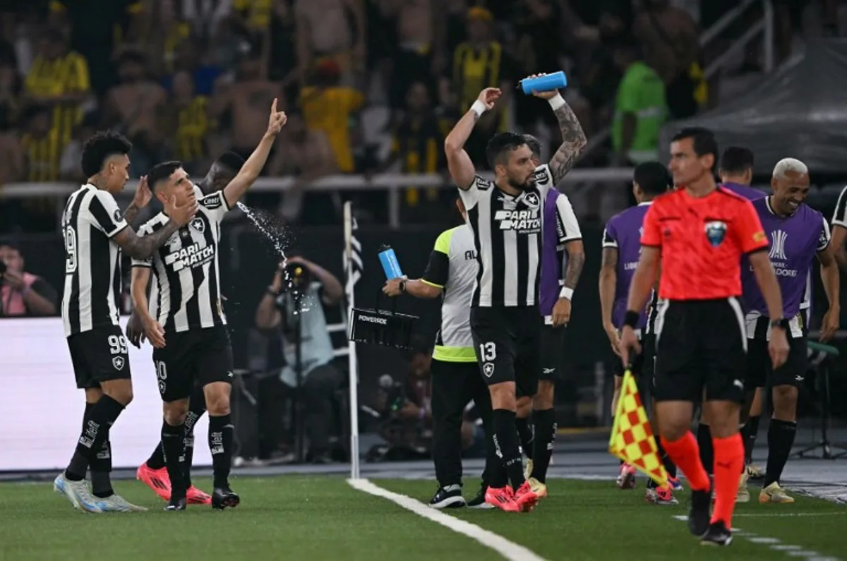 Botafogo's Venezuelan forward #10 Jefferson Savarino (2-L) celebrates with teammates forward #99 Igor Jesus and defender #13 Alex Telles after scoring his team's first goal during the Copa Libertadores semi-final first leg football match between Brazil's Botafogo and Uruguay's Peñarol at the Olimpico Nilton Santos stadium in Rio de Janeiro, Brazil, on October 23, 2024.  Mauro PIMENTEL / AFP