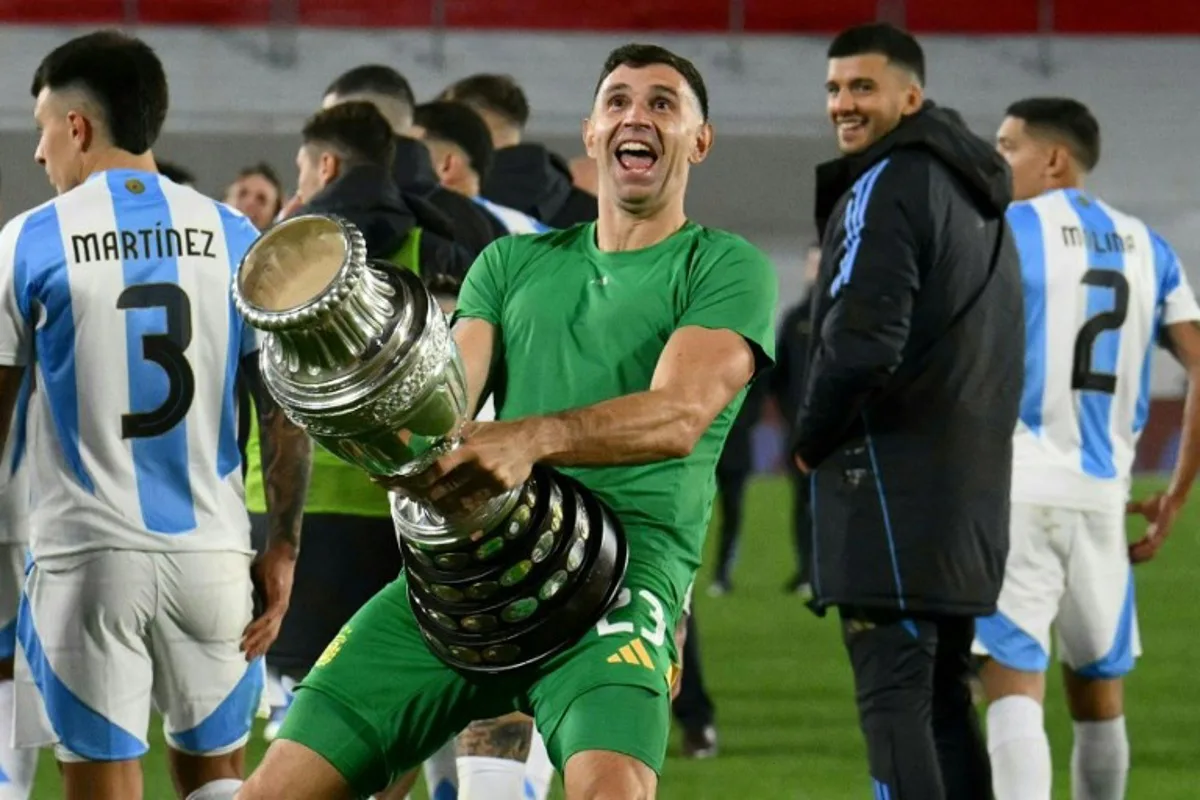 Argentina's goalkeeper Emiliano Martinez gestures as he celebrates with a replica of the Copa America trophy after winning the 2026 FIFA World Cup South American qualifiers football match between Argentina and Chile at the Mas Monumental stadium in Buenos Aires on September 5, 2024.  Luis ROBAYO / AFP