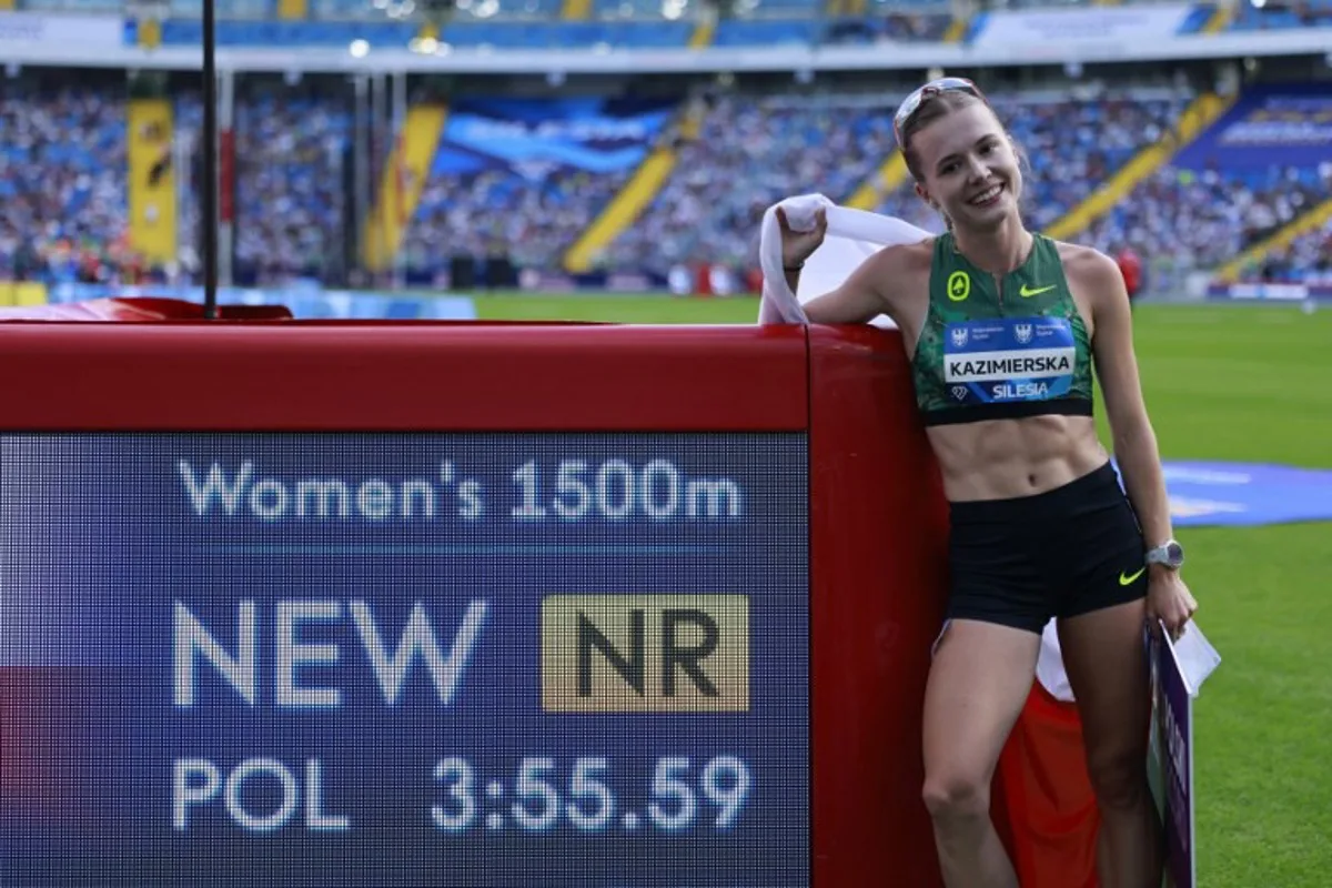 Poland's Klaudia Kazimierska celebrates by the new Polish record banner after placing fourth in the 1500 m event of the Silesia Diamond League athletics meeting in Katowice, Poland, on August 23, 2026.  Wojtek RADWANSKI / AFP