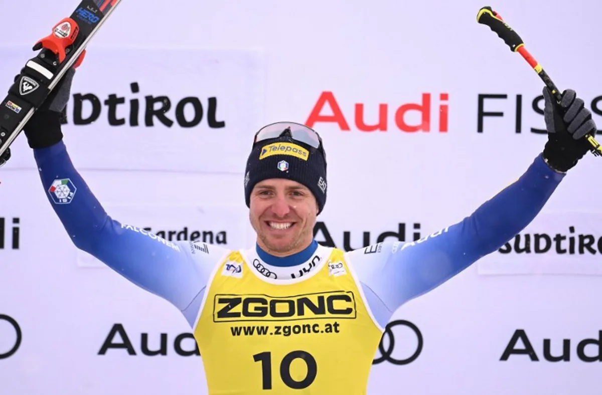 Italy's Mattia Casse celebrates on the podium after winning the Men's Super-G race as part of the FIS Alpine ski World Cup 2024-2025, in Val Gardena on December 20, 2024.  Marco BERTORELLO / AFP