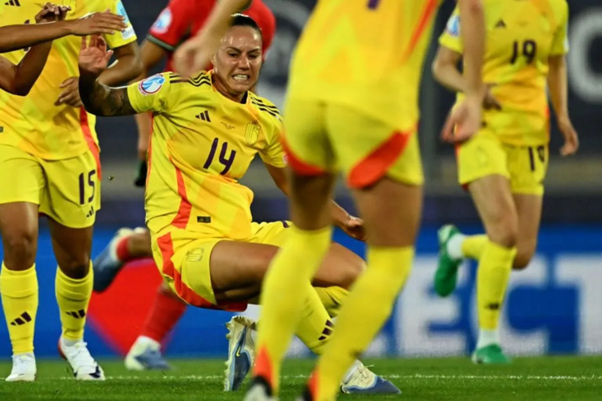 Belgium's forward #14 Jassina Blom (C) grimaces as she falls to the pitch and is later stretchered off, during the UEFA Women's Euro 2025 Group B football match between Portugal and Belgium at the Stade de Tourbillon in Sion, on July 11, 2025. Fabrice COFFRINI / AFP