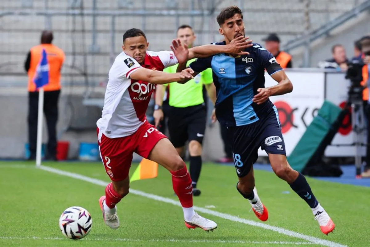 Le Havre's French defender #18 Yanis Zouaoui (R) fights for the ball with Monaco's Brazilian defender #02 Vanderson (L) during the French L1 football match between Le Havre AC and AS Monaco at the Stade Oceane in Le Havre, northwestern France on August 23, 2026. Fred TANNEAU / AFP